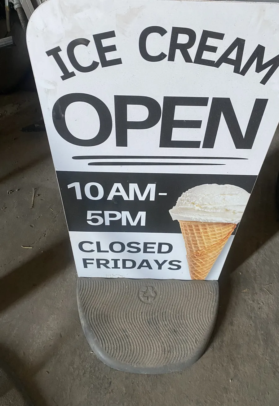 Pavement swinger with a printed ice cream open sign and a heavy recycled-plastic base, in for a re-skin
