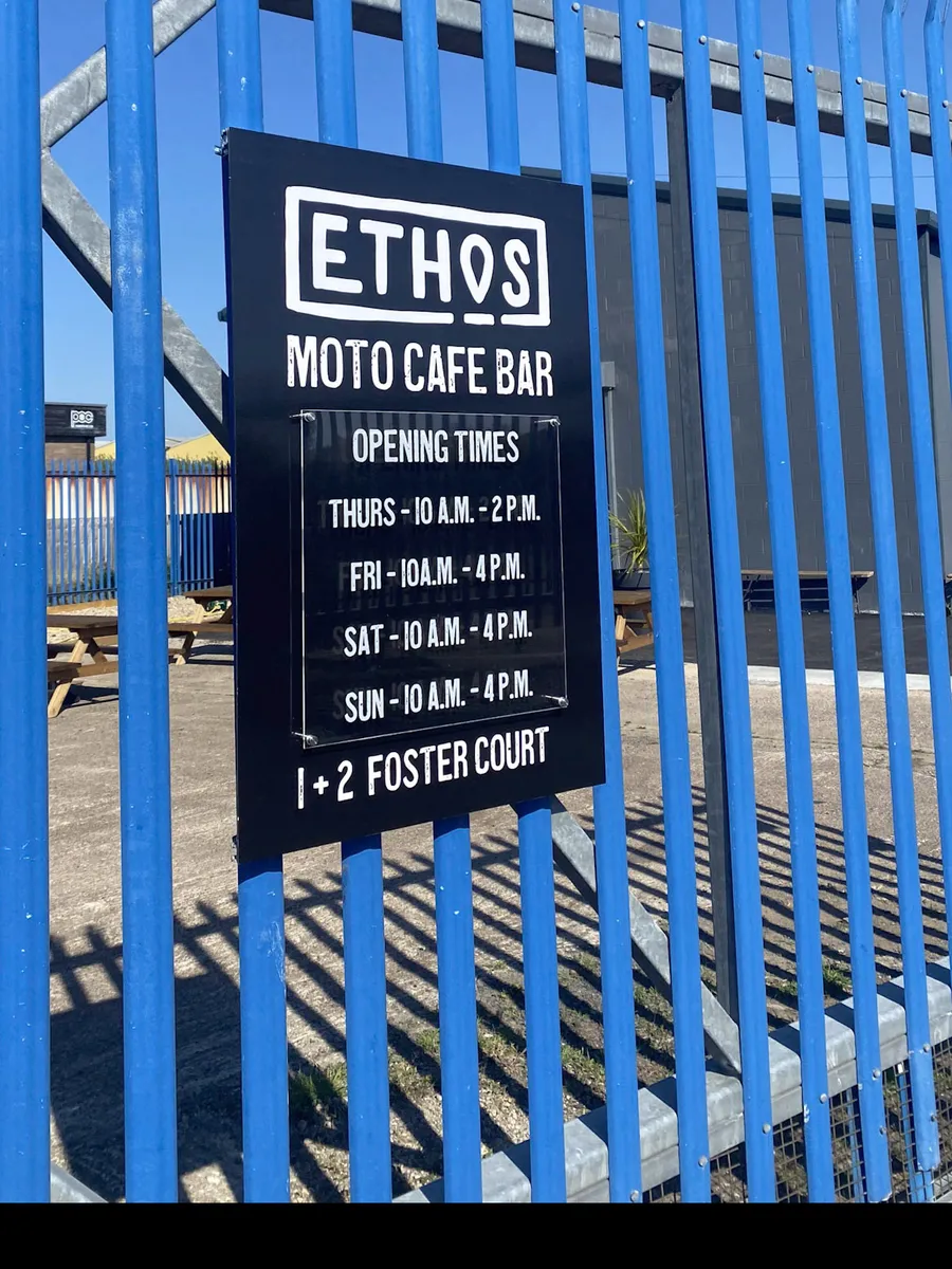 Black printed ACM panel with white lettering for Ethos Moto Cafe Bar on a palisade fence