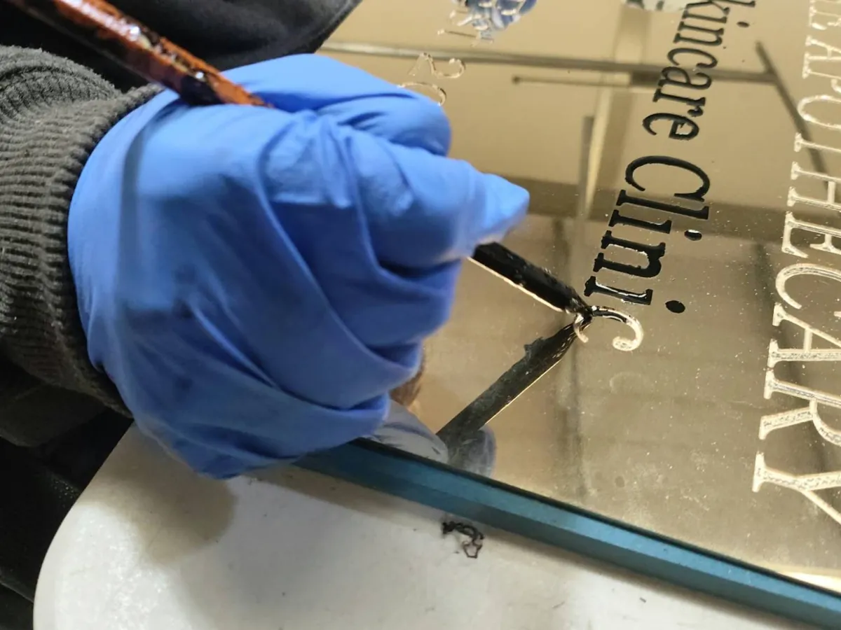 Black epoxy being brushed into the engraved lettering by hand