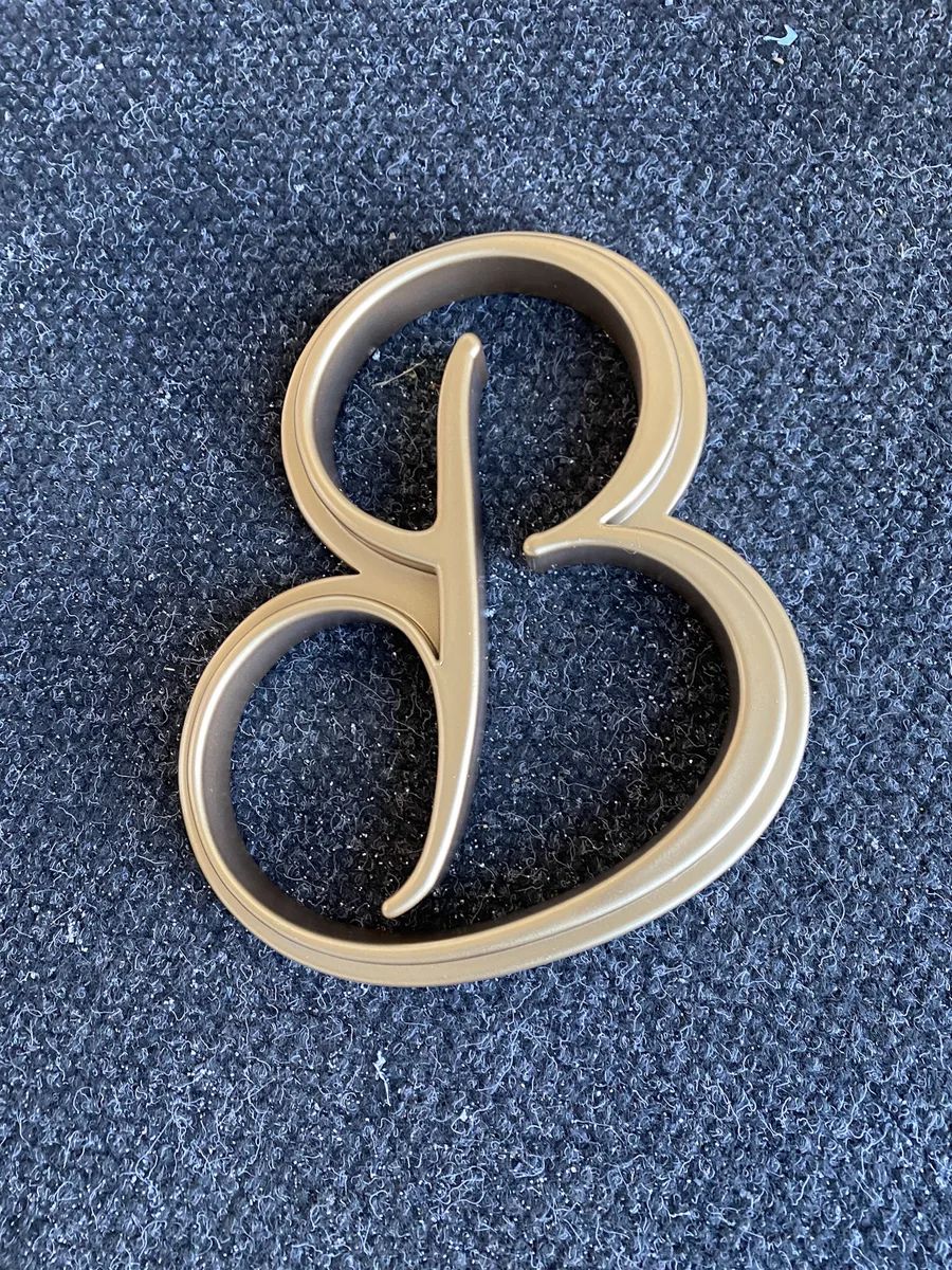 A brass letter for Hannah Bell Hair, fresh from the machine in the NBNE workshop