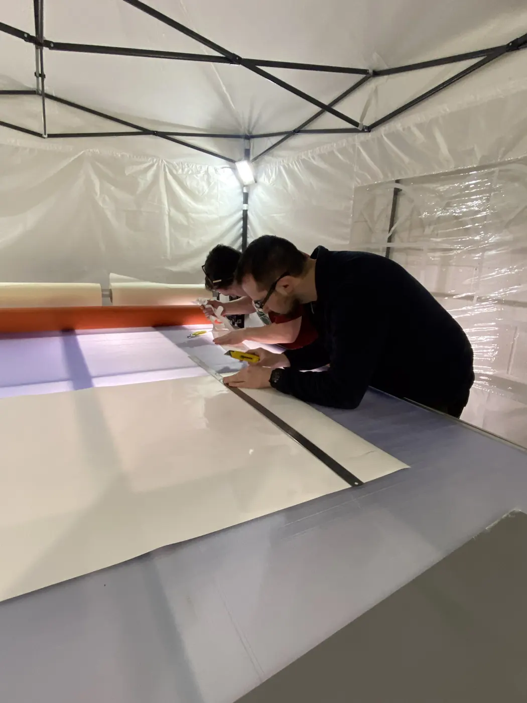Applying cut vinyl to a panel in the workshop